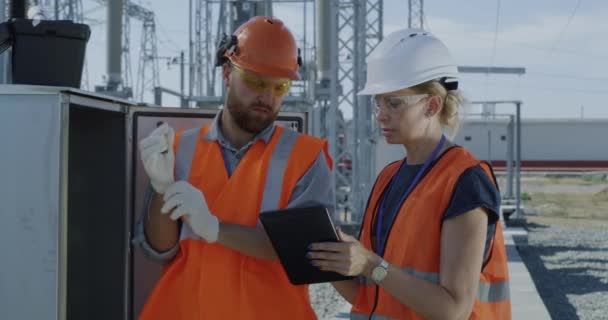 Ingenieros revisando caja de transformadores en planta de energía — Vídeos de Stock