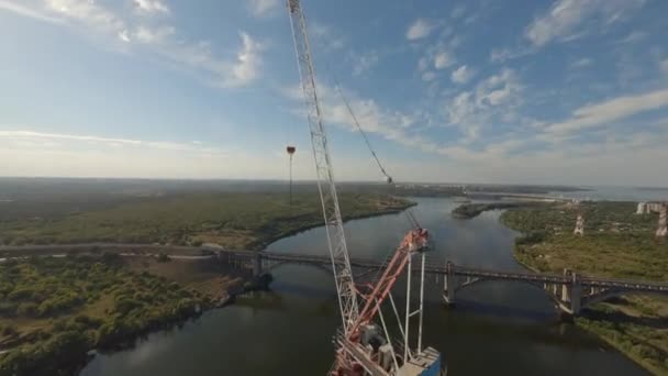 川の未完成の橋の近くのクレーン — ストック動画