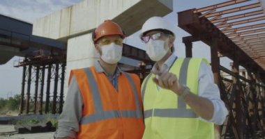 Maskeli mühendisler işi tartışıyor.