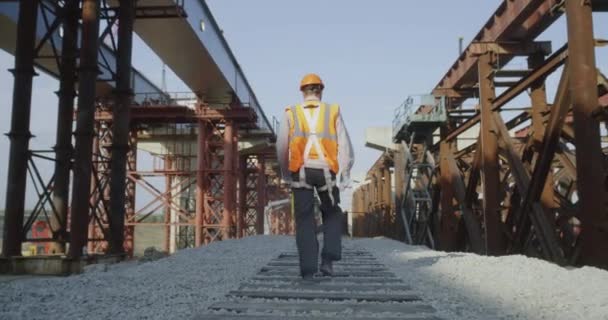 Construtor irreconhecível andando no canteiro de obras — Vídeo de Stock