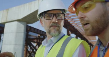 Erkek müteahhitler dizüstü bilgisayarda taslak inceliyor