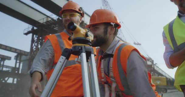 Theodolite-ot használó vállalkozók szeles napokon — Stock videók