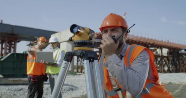 A teodolitot együtt alkalmazó férfi felmérők — Stock videók