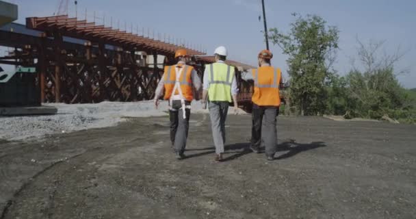 Professionelle Ingenieure auf dem Weg zur unfertigen Brücke — Stockvideo