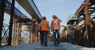 Bitmemiş köprünün yanında yürüyen inşaatçılar