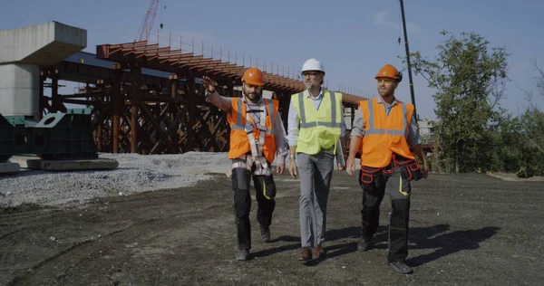 Szakmai mérnökök a befejezetlen híd felé sétálva — Stock Fotó