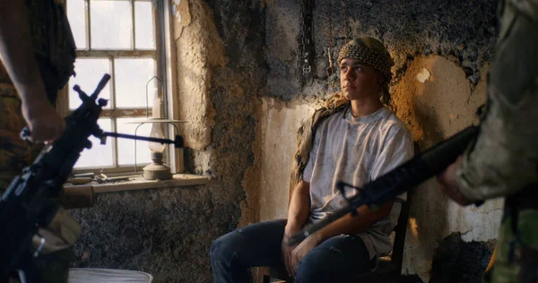 Male soldier interrogating young prisoners — Stock Photo, Image