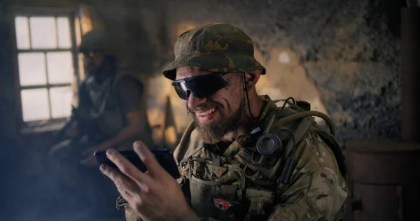 Homme militaire utilisant un smartphone à l'intérieur du bâtiment grungy — Photo