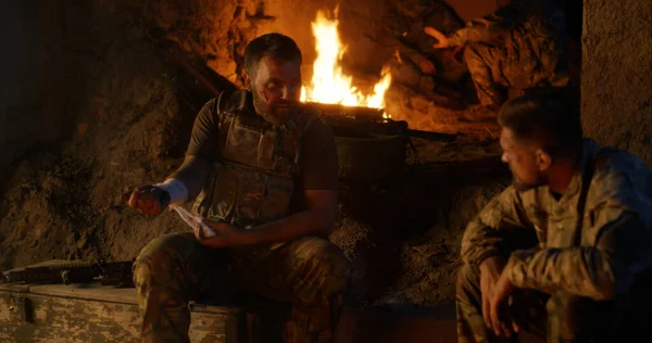 Kızgın askerler ateşin yanında dinleniyor. — Stok fotoğraf