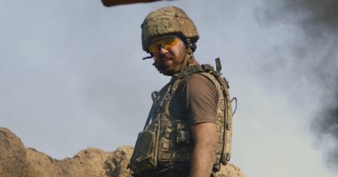 Yetişkin asker savaş sırasında duman içinde duruyor.