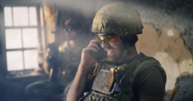 Mutlu asker, üsteki akıllı telefondan konuşuyor.