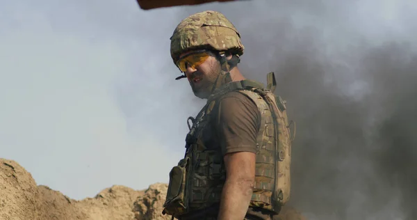 Взрослый солдат, стоящий в дыму во время войны — стоковое фото