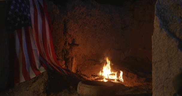 Fuego ardiendo cerca de la bandera de EE.UU. por la noche — Vídeo de stock