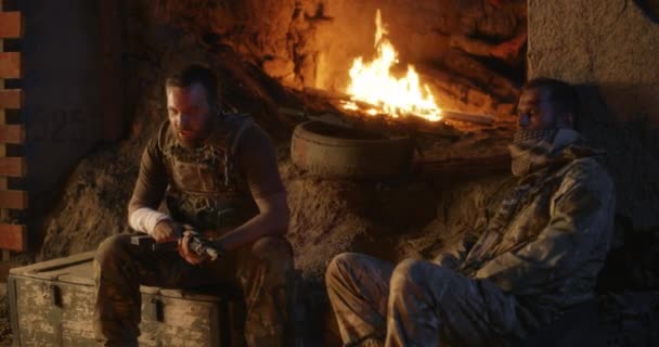 Angry military men resting near fire — Stock Video