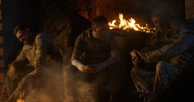 Askerler kamp ateşi etrafında dinleniyor.