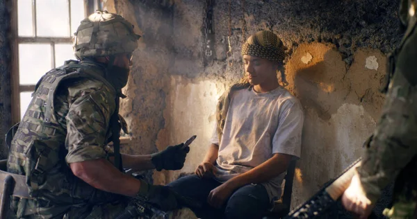 Male soldier interrogating young prisoners — Stock Photo, Image