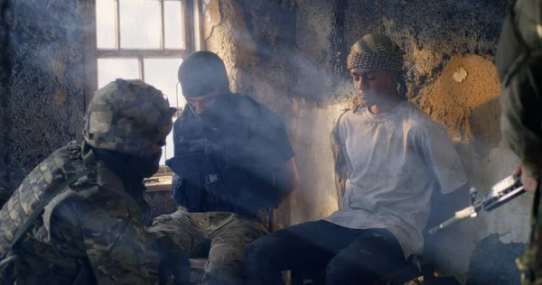 Mannelijke soldaat ondervraagt jonge gevangenen — Stockfoto