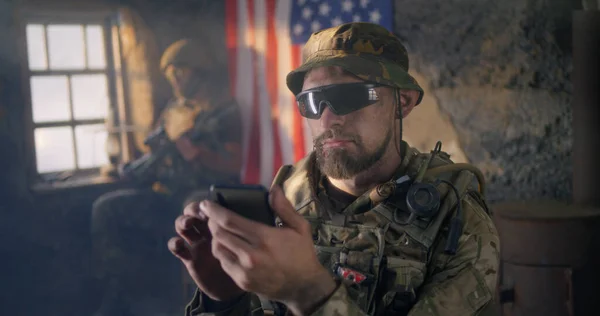 Στρατιωτικός που χρησιμοποιεί smartphone στο εσωτερικό του grungy κτιρίου — Φωτογραφία Αρχείου
