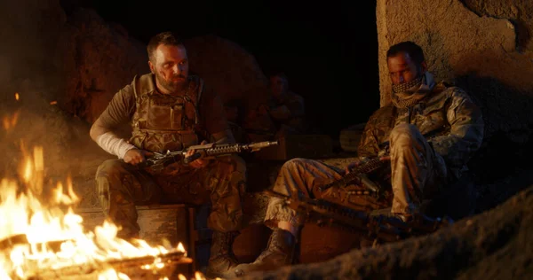 Angry military men resting near fire — Stock Photo, Image