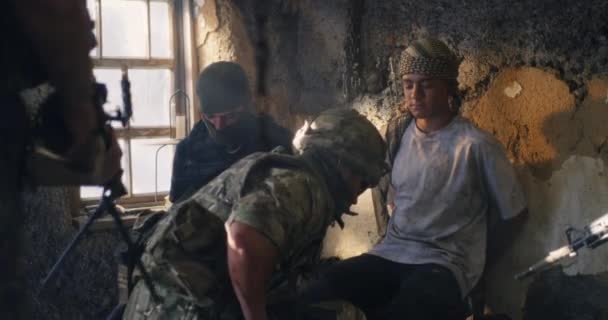 Male soldier frisking captive terrorists — Stock Video