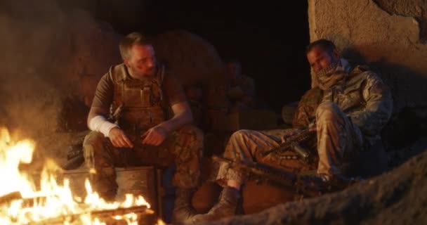 Angry military men resting near fire — Stock Video