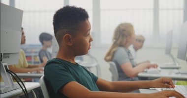 İlkokul öğrencileri bilgisayarlar üzerinde yaratıcı projeler üzerinde çalışıyorlar. Dijital Yetenek Uygulayan Çeşitli Çocuklar, Bilgisayar Bilimi Sınıfı 'nda Programlama Öğrenimi. İnteraktif STEM Öğrenme. Doli Vuruşu.