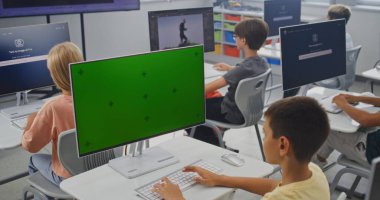 İlkokul çocuğu Chroma Key Holder ile birlikte PC Monitor 'da Yaratıcı Proje üzerinde çalışıyor. Genç Çocuklar 3D Modellik Yapıyor, Dijital Sanat Dersinde Yapay Zeka Jeneratörünü Bilgisayarlarda Kullanıyor. STEM Öğrenme.