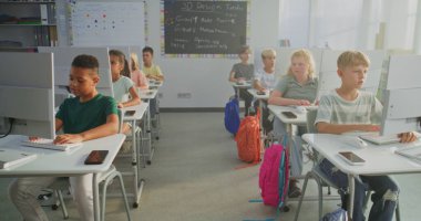 İlkokul öğrencileri bilgisayarlar üzerinde yaratıcı projeler üzerinde çalışıyorlar. Dijital Yetenek Uygulayan Çocuklar Grubu, Bilgisayar Bilimleri Sınıfı 'nda Programlama Öğrenimi. İnteraktif STEM Öğrenme. Sabit Çekim.