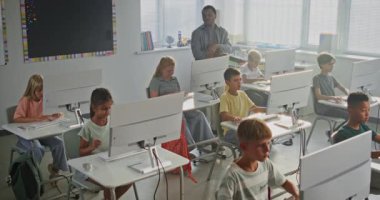 İlkokul çocukları bilgisayar kullanıyor, yaratıcı 3D tasarım projeleri yapıyor. Programlama Dersi sırasında Afrikalı Amerikalı Öğretmenler Kızlara ve Oğlanlara Kodlamada Yardım Ediyor. BTMM Eğitim. Yüksek Açı.