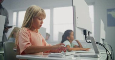 Bilgisayar üzerinde çalışan ilkokul kızı. Dijital Yetenekler Uygulamada Genç Öğrenciye Rehber ve Bilgisayar Bilimi Sınıfı 'nda Eğitim Programı. Etkileşimli BTMM Öğrenme.