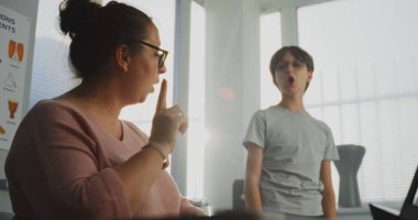 İlkokulda Ses Dersinde Şarkı Söyleyen Yetenekli Çocuk, Performanstan Önce Prova. Müzik Öğretmeni Piyano Çalıyor, Genç Öğrenciyi Destekliyor ve Eğitiyor. Müzik Eğitimi, Şarkı Söyleme Sınıfı.