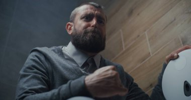 Tuvalette oturan ve tuvalette ishal ve mide acısından muzdarip bir adam. İş adamı Modern Ofis 'te Rahatsızlık, Hazımsızlık ve Sindirim Rahatsızlığı Yaşıyor. Düşük Açı.