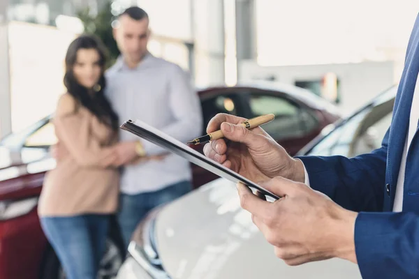 Händlerhände Mit Klemmbrett Und Glücklicher Familie Rücken — Stockfoto