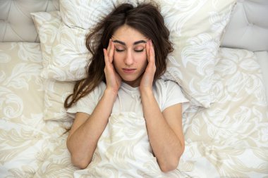 Hasta ve çekici bir kız yatakta yatıp ilaç alıyor. Koronavirüs.