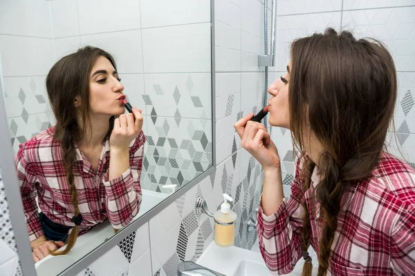beautiful girl in the bathroom applies cream on her face. beauty concept.