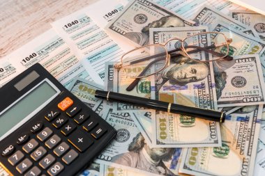 Masada 1040 vergi formu, kalem hesap makinesi ve dolar var. iş kavramı.
