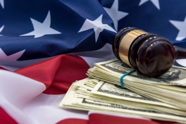 Amerika bayrağının üzerinde kelepçe ve dolar banknotları olan yargıç tokmağı. Hukuk ya da suç kavramı. Adalet