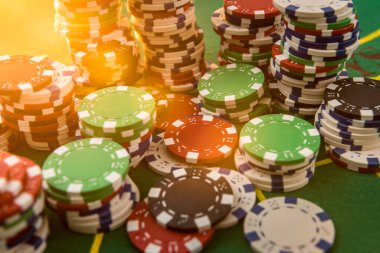 Kumarhane poker fişleri yeşil keçeli arka planda. Hepsi başarı oyunu için..