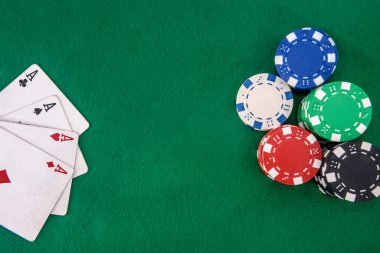 Kumar konsepti. Yeşil masada poker fişleri ile dört as kombinasyonu