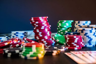 Poker fişleri ve oyun kartları siyah masada.