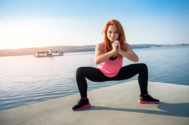 Sportif fit kadın gündüz vakti göl kenarında yoga yapıyor. Sağlıklı yaşam egzersizi konsepti.