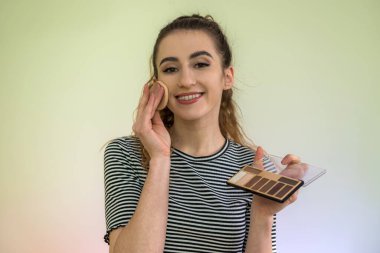 Makyaj fırçaları olan çekici kız yeşile izole edilmiş. Güzellik ve sağlık kavramı