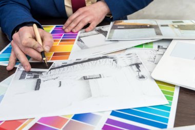 Ev tasarımcısı, modern apartman dairesi için renk kataloğu çizimi yapıyor. Mimari ev planı ve renk örneği, kalem.