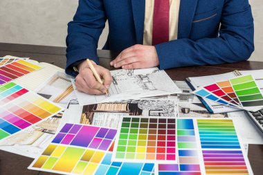 Tasarımcı, modern iç mekan için ev çizimi ve renk örnekleyici üzerinde çalışıyor. Mimarlık projesi, ofis işyeri