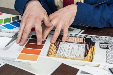 Genç tasarımcı yeni bir proje üzerinde çalışıyor. Modern bir apartman yenileme için mükemmel rengi seçiyor.