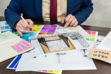 Tasarımcı, modern iç mekan için ev çizimi ve renk örnekleyici üzerinde çalışıyor. Mimarlık projesi, ofis işyeri