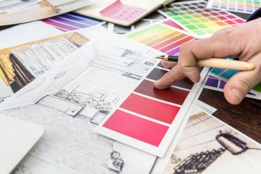 Ev tasarımcısı, modern apartman dairesi için renk kataloğu çizimi yapıyor. Mimari ev planı ve renk örneği, kalem.