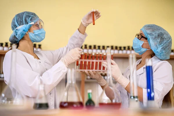 Zwei Frauen Chemielabor Untersuchen Reagenzgläser Mit Roter Substanz — Stockfoto