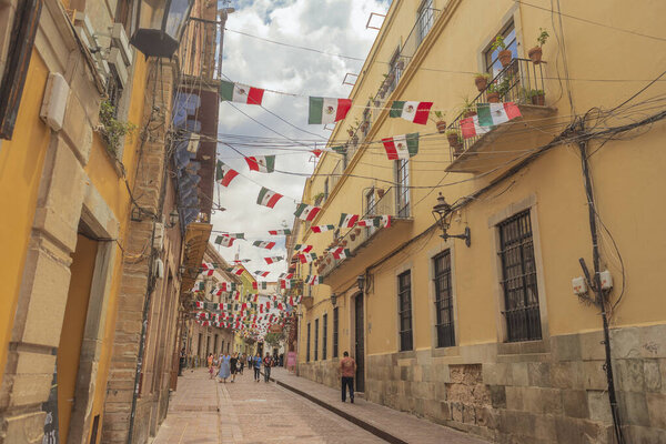 097 09 2025 Guanajuato Mexico Charming balconies with Mexican flags in the alleys of Guanajuato, Mexico, showcasing vibrant architecture, cultural identity, and festive heritage.