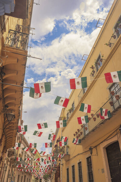 097 09 2025 Guanajuato Mexico Charming balconies with Mexican flags in the alleys of Guanajuato, Mexico, showcasing vibrant architecture, cultural identity, and festive heritage.